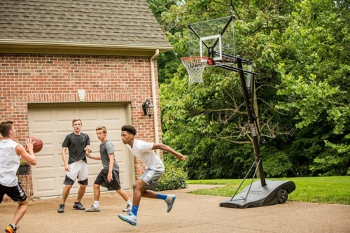 Kids playing basketball using a portable outdoor hoop